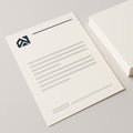 Bedrukt briefpapier op A4, met logo en huisstijl, naast een stapel vellen