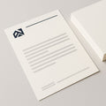 Bedrukt briefpapier op A4, met logo en huisstijl, naast een stapel vellen